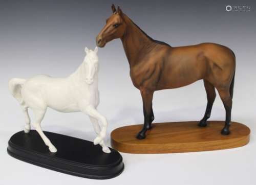 A Beswick matt bay model of 'Arkle', raised on a wooden base, a Royal Doulton white glazed horse