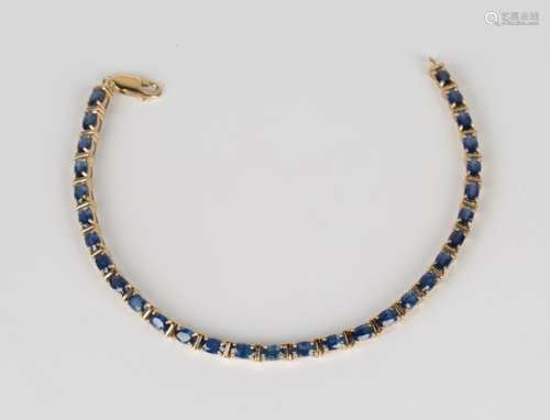 A gold and sapphire bracelet, claw set with a row of oval cut sapphires, on a sprung hook shaped