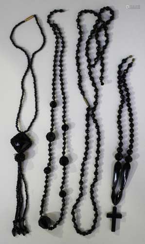 Four Victorian and later moulded black glass necklaces, including one with a black composition