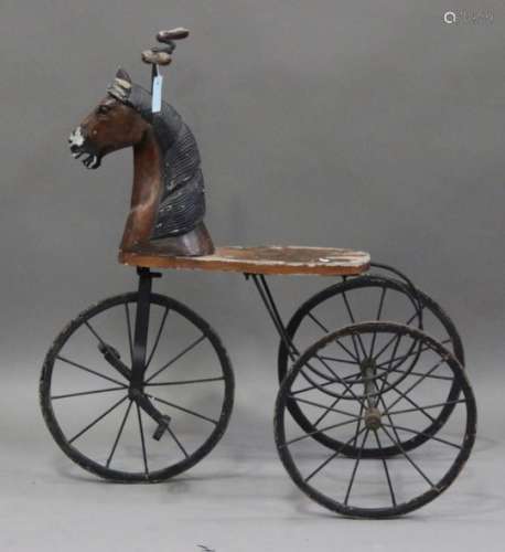 A late 20th century wrought metal and carved wooden child's tricycle, the front carved in the form