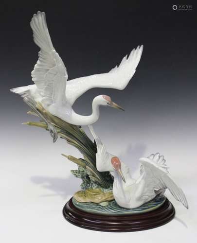 A Lladro porcelain group of cranes, No. 1456, one bird with outstretched wings on the water, another