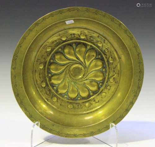 A 17th century Nuremberg brass alms dish, the centre with a spiral gadrooned boss, the raised rim