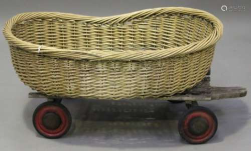 An early 20th century wooden slatted dog cart and a wicker dog basket, length 100cm.Buyer’s