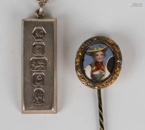 A 19th century gilt metal and enamelled stickpin, decorated with a portrait of a lady wearing a hat,