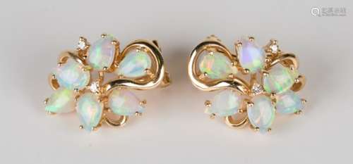 A pair of gold, opal and diamond earclips, each in a naturalistic spray design, mounted with six