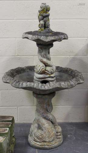A late 20th century cast composition stone garden fountain of sectional form, the fish and putto