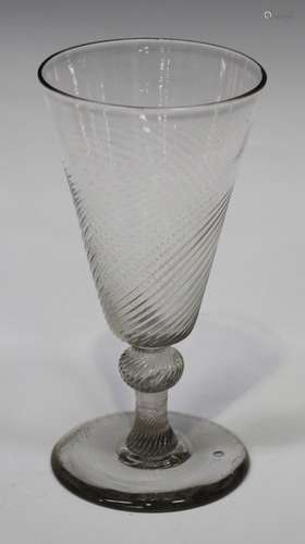 A wrythen moulded ale glass, early 18th century, the pointed rounded funnel bowl raised on a