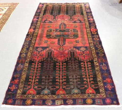 A Hamadan long rug, North-west Persia, mid-20th century, the central red compartment enclosing a