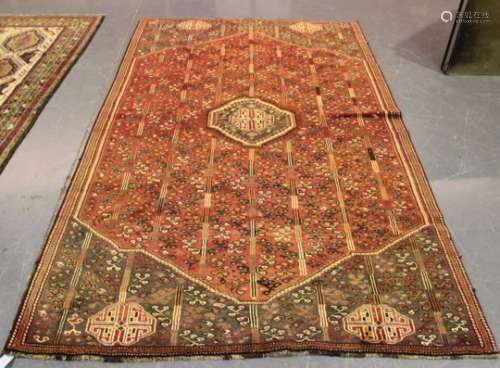 A Shiraz rug, South-west Persia, mid-20th century, the red field with a lozenge medallion, profusely