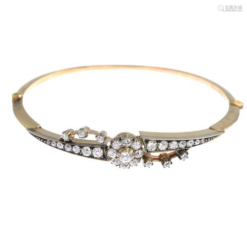 An early 20th century gold diamond hinged bangle.Estimated total diamond weight 1.30cts.Inner