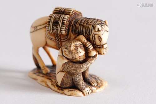 Netsuke en ivoire rehaussé de brun représentant un…