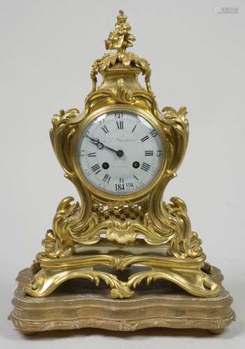 Petite pendule de style Louis XV en bronze doré. C…