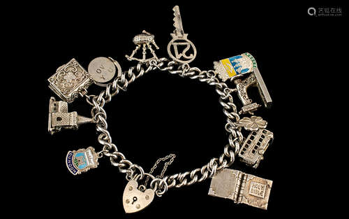 Silver Charm Bracelet. Early 20th Century charm bracelet with 11 charms, London bus, sewing machine,