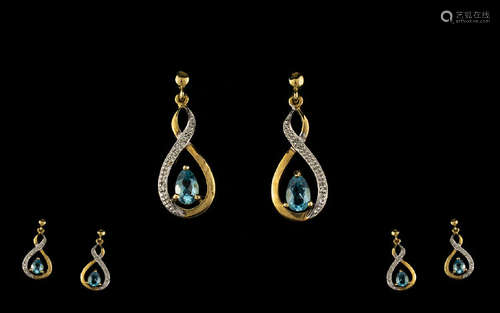 Sky Blue Topaz and Diamond Drop Earrings, each earring having a pear cut sky blue topaz, set to