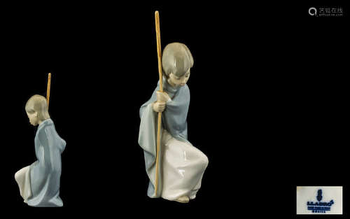 Lladro Nativity Figure of a Shepherd Boy, kneeling down with a crook in hand. 7 inches in height.