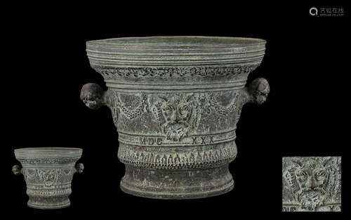 An Antique Bronze Mortar of typical form with moulded form and lion mask decoration. With twin