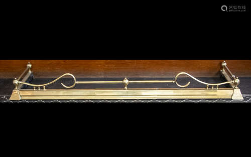 An Adjustable Brass Fender of Typical Form with a plinth base and scroll gallery. Length 57 inches