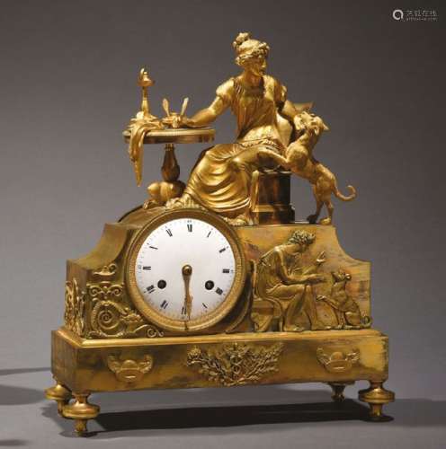 Pendule en bronze doré présentant une femme assise…
