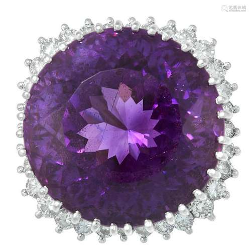 AN AMETHYST AND DIAMOND RING set with a large, round