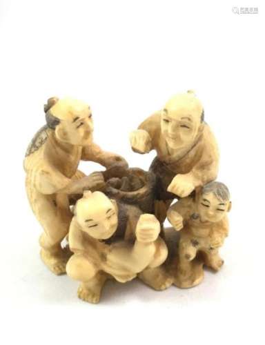 Un netsuké en ivoire sculpté figurant un groupe de…