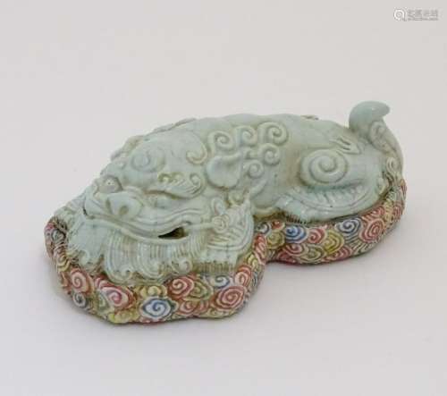 A recumbent Chinese foo dog with a crackle glaze lying
