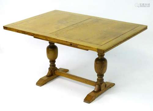 A late 20thC oak dining table with a rectangular table