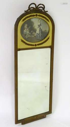 An early 20thC mirror surmounted by a ribbon bow and