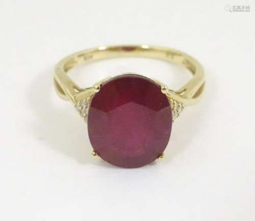 A 10k gold ring set with large red stone flaked by chip