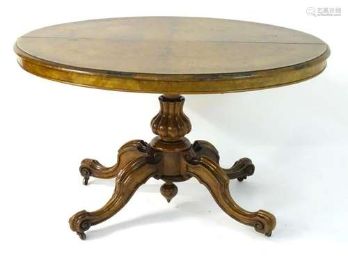 A late 19thC walnut loo table with a gadrooned pedestal