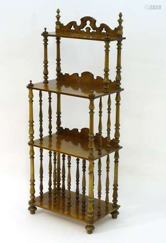 A 20thC burr walnut four tier whatnot with a shaped