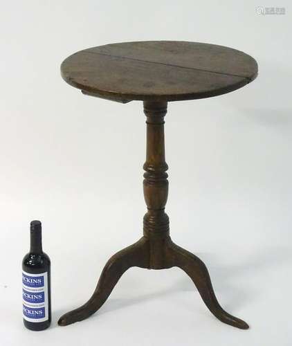 A late 18thC oak tripod table with a circular table top