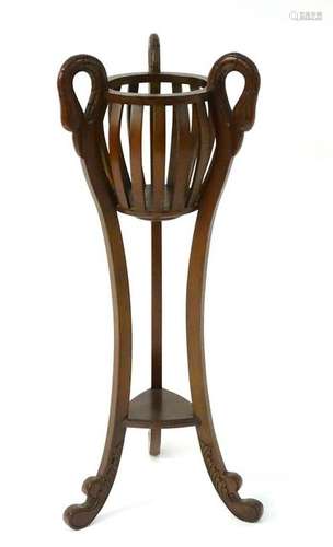 A 20thC mahogany planter / plant stand with a bulbous