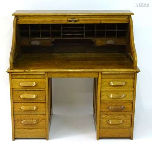 A mid 20thC oak 'Lebus Desk' with a tambour roll top