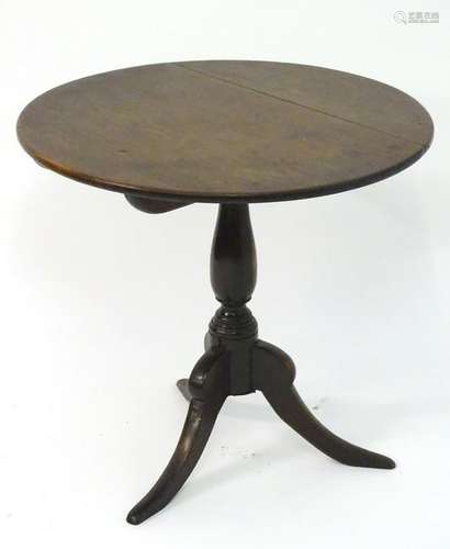 An early 19thC oak topped tripod table with a circular