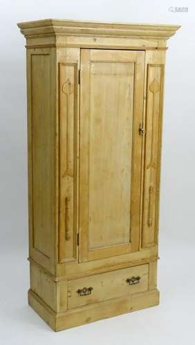 An early 20thC pine cupboard with a moulded cornice