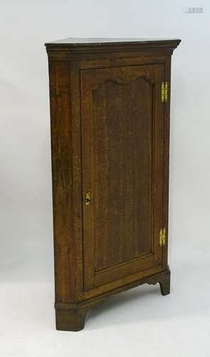 A late Georgian oak freestanding corner cupboard,