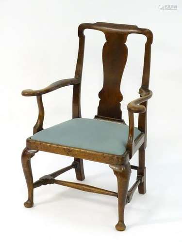 A George I mahogany open armchair with a shaped top