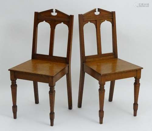 A pair of early 20thC oak hall chairs with broken