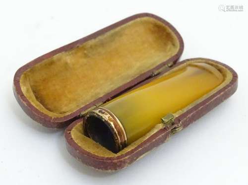 A cheroot mouthpiece of faux amber, contained within a