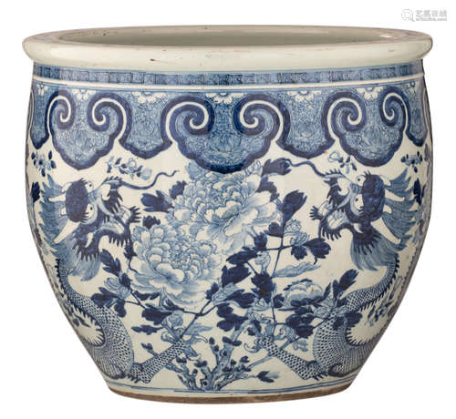 A Chinese blue and white fish bowl, decorated with a pair of dragons, wallowing between blossoming peonies and flower branches, the shoulder with ruyi lappets, H 45,5 - ø 52 cm