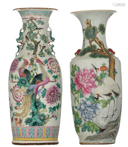 Two Chinese famille rose vases, one vase decorated with phoenix, birds and cranes on flower branches and a pair of ducks in a lotus pond, with Fu lion handles, the other vase decorated with cranes and blossoming peonies, the reverse with a text, the handles shaped like a Fu lion's head, H 59 - 60 cm