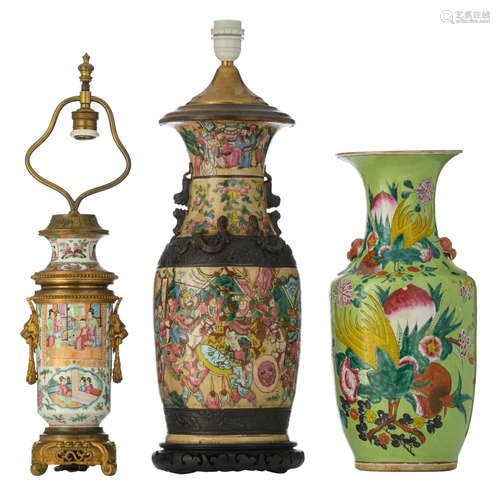 A Chinese lime ground famille rose vase, decorated with flowers, a Buddha's hand, pomegranates and peaches, with Fu lion's head shaped handles; added: a ditto stoneware and a ditto Canton vase, both vases mounted as a lamp, H 44,5 - 62,5 cm