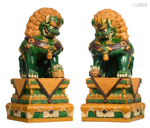 A pair of large guardian Fu lions in sancai, on matching ditto bases, H 101,5 - 103 - W 45 - 45,5 - D 54,5 - 55 cm 