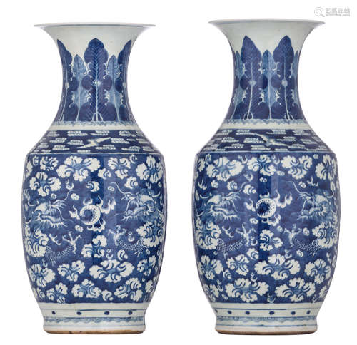 A pair of Chinese blue and white vases, decorated with dragons, chasing the flaming pearl amidst clouds, the neck with foliate lappets and the shoulders with scrolling clouds and bats, H 49,5 - 50 cm  