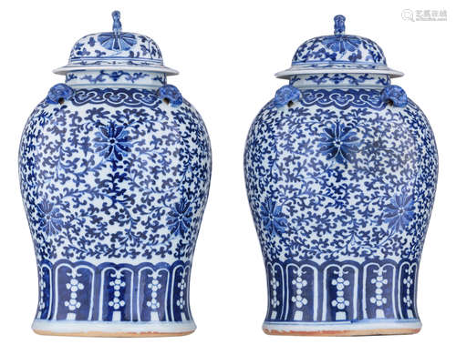 A pair of Chinese blue and white overall floral decorated vases and covers, with Fu lion knobs on the covers, H 44 - 44,5 cm