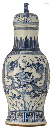 A large Chinese blue and white baluster shaped vase and cover, decorated with a pair of dragons, dancing amidst flower branches, the neck and foot rim painted with upright leaves, with a Fu lion seated on top of the cover 19thC, H 93 cm 