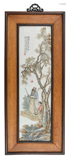 A Chinese polychrome decorated porcelain plaque in a wooden frame, decorated with a literati and his servant under a tree, with a signed text, 39 x 93 cm (frame)