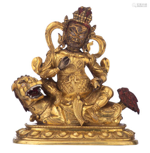 A Sino-Tibetan Tantric Buddhist figure of Vaishravana riding a foo lion, with a Qianlong mark, gilt bronze and polychrome paint, H 16 cm