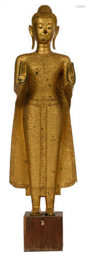 A Thai gilt bronze standing Buddha, decorated with glass inlay, on a wooden base, H 193 cm