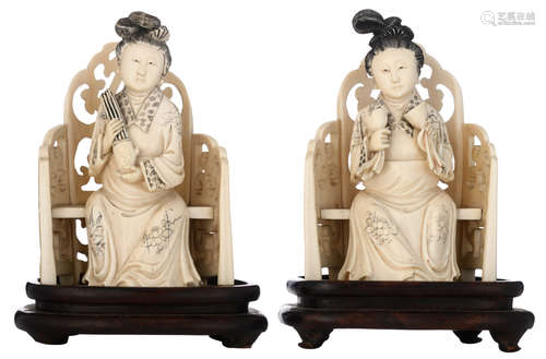 Two Chinese probably Canton  ivory court ladies, seated on their throne, engraved and coloured, late Qing dynasty, on an exotic wooden base, H 15 - 17,5 (with base) - W 10,5 cm, total weight 689 g (without base)Added expertise report according to CITES legislation. For European Community use only.